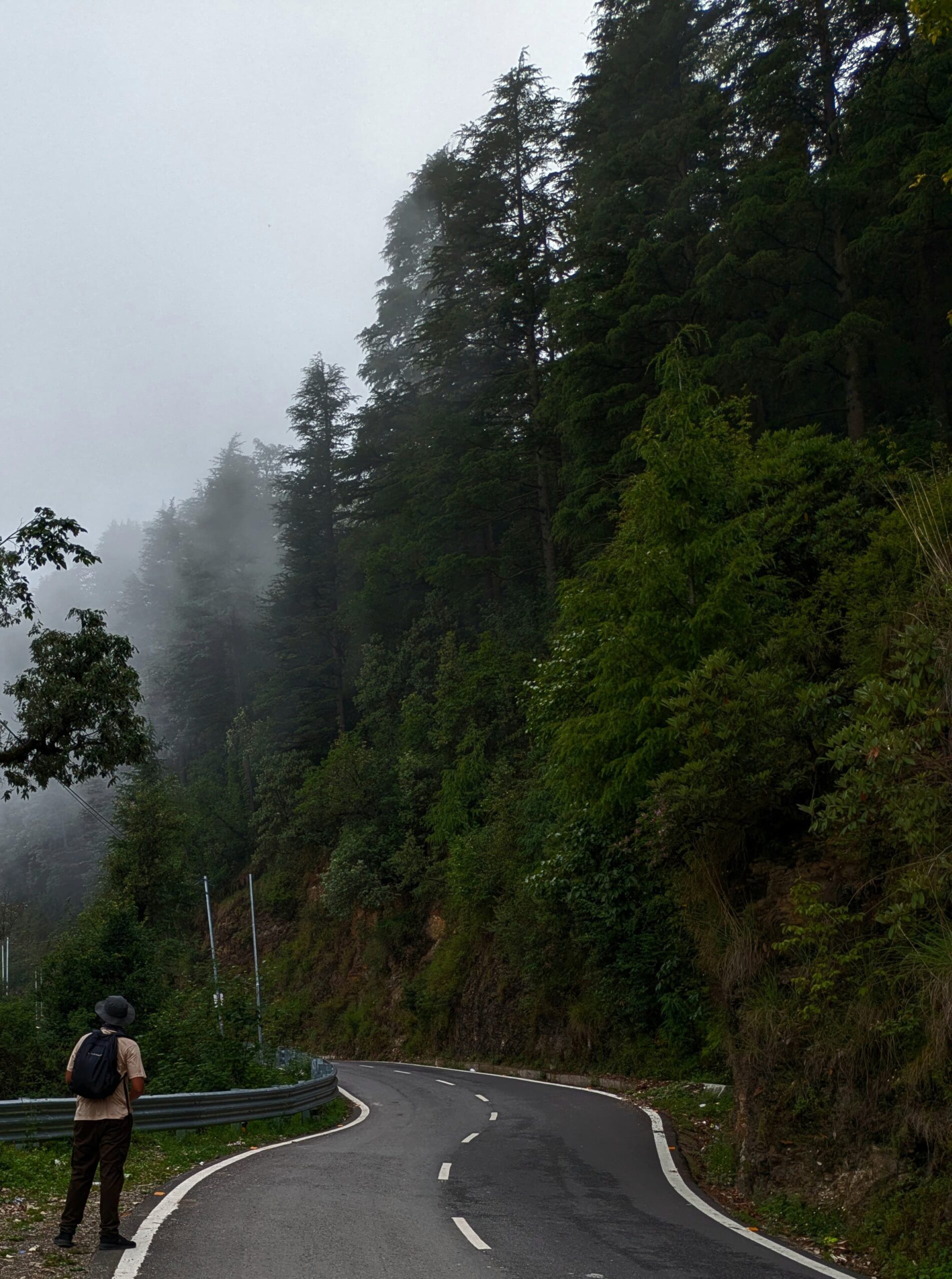 Image of a man walking on a mountainous road.